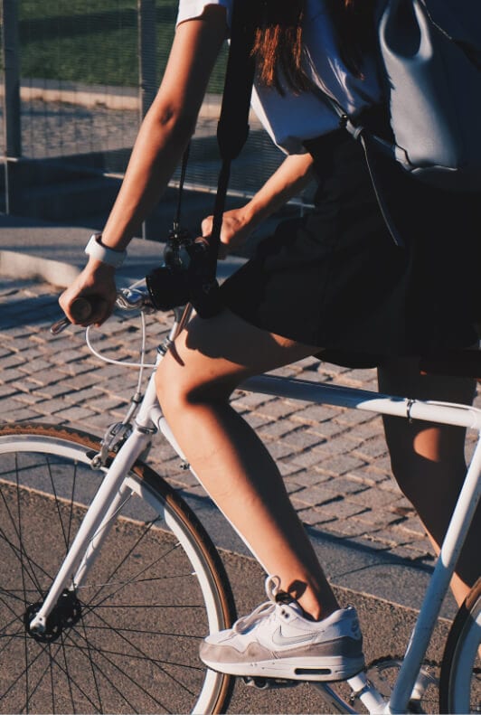 dievča na bicykli s Nike Air Max bielymi teniskami 